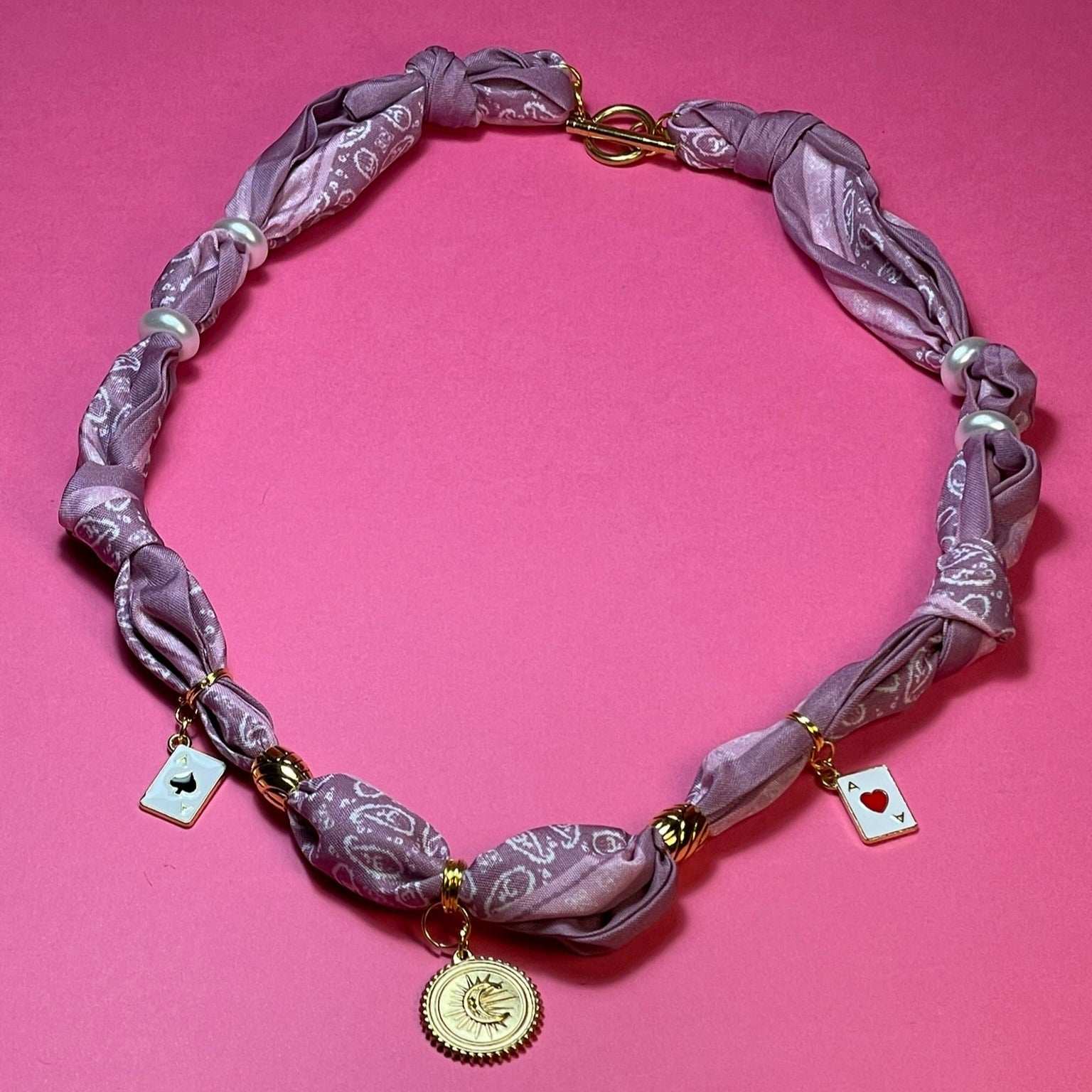 Collar artesanal con dije dorado y pañuelo trenzado, diseño bohemio hecho a mano por Hilma.