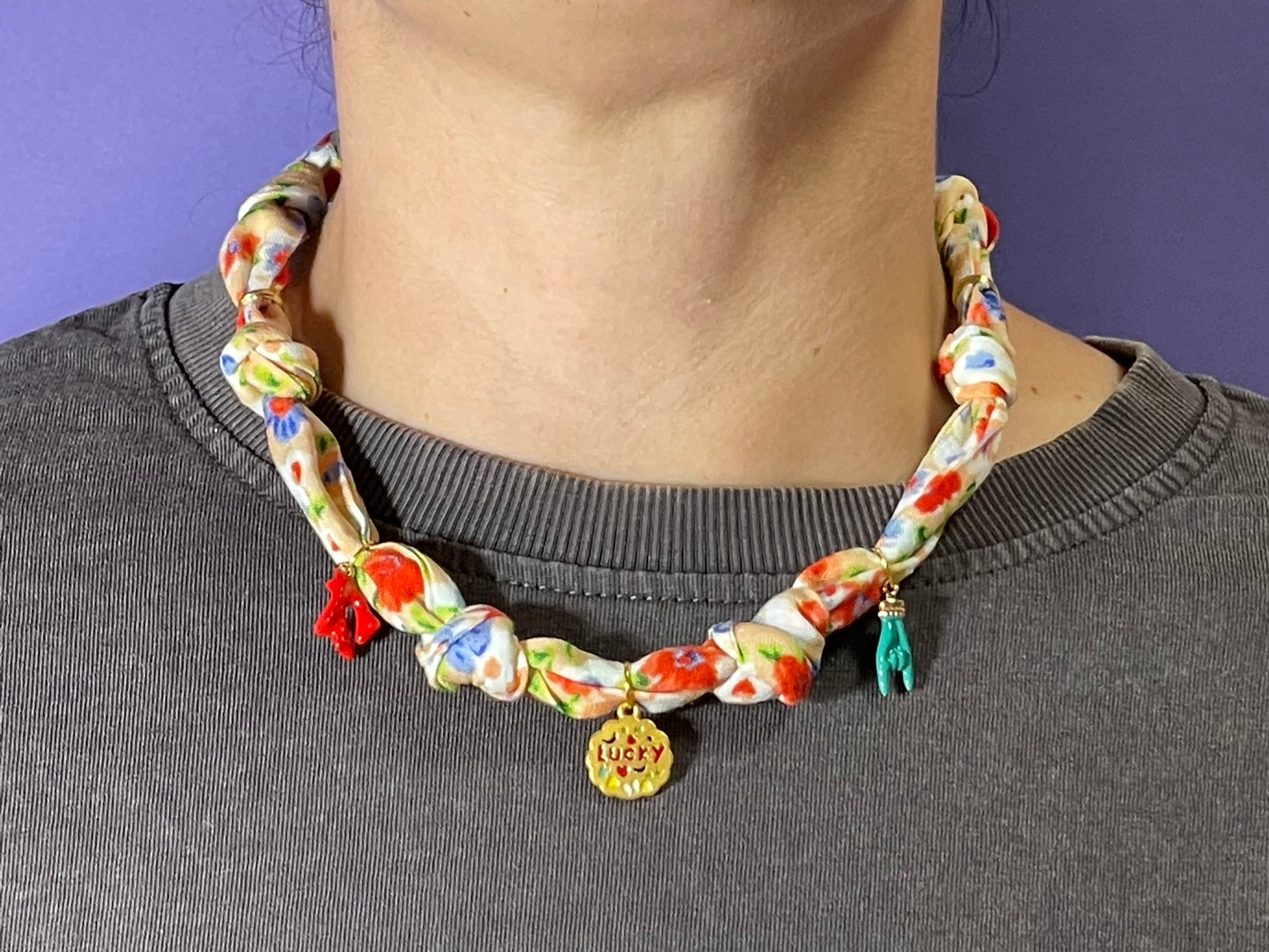 Collar artesanal con dije dorado y pañuelo trenzado, diseño bohemio hecho a mano por Hilma.