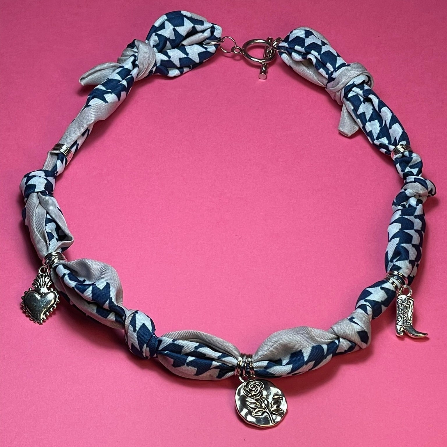 Collar artesanal con dije dorado y pañuelo trenzado, diseño bohemio hecho a mano por Hilma.