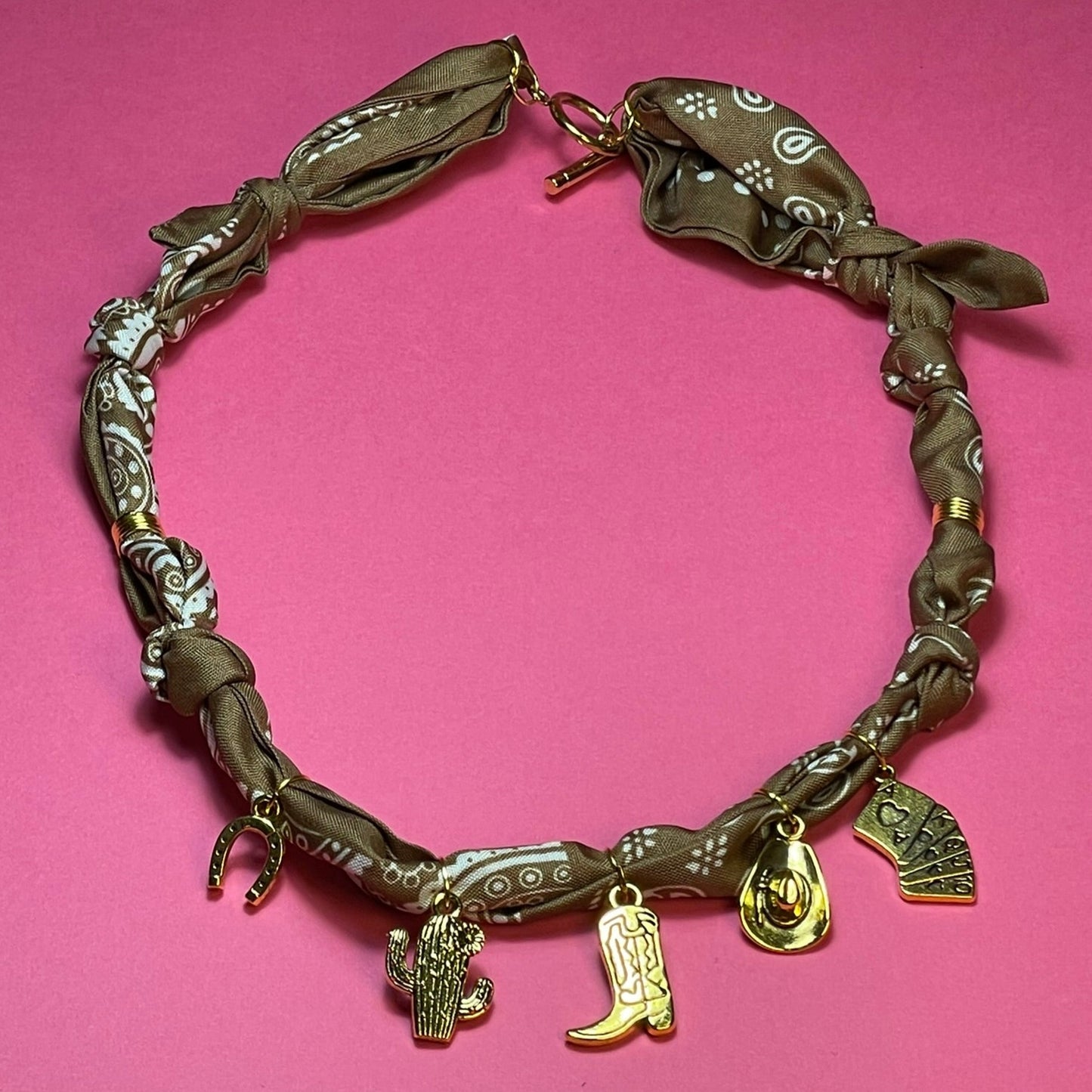 Collar artesanal con dije dorado y pañuelo trenzado, diseño bohemio hecho a mano por Hilma.