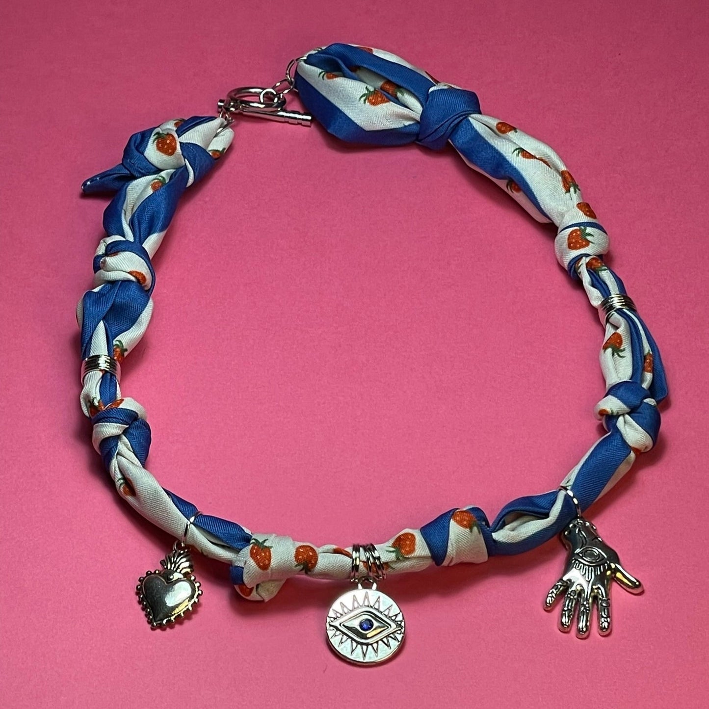 Collar artesanal con dije dorado y pañuelo trenzado, diseño bohemio hecho a mano por Hilma.