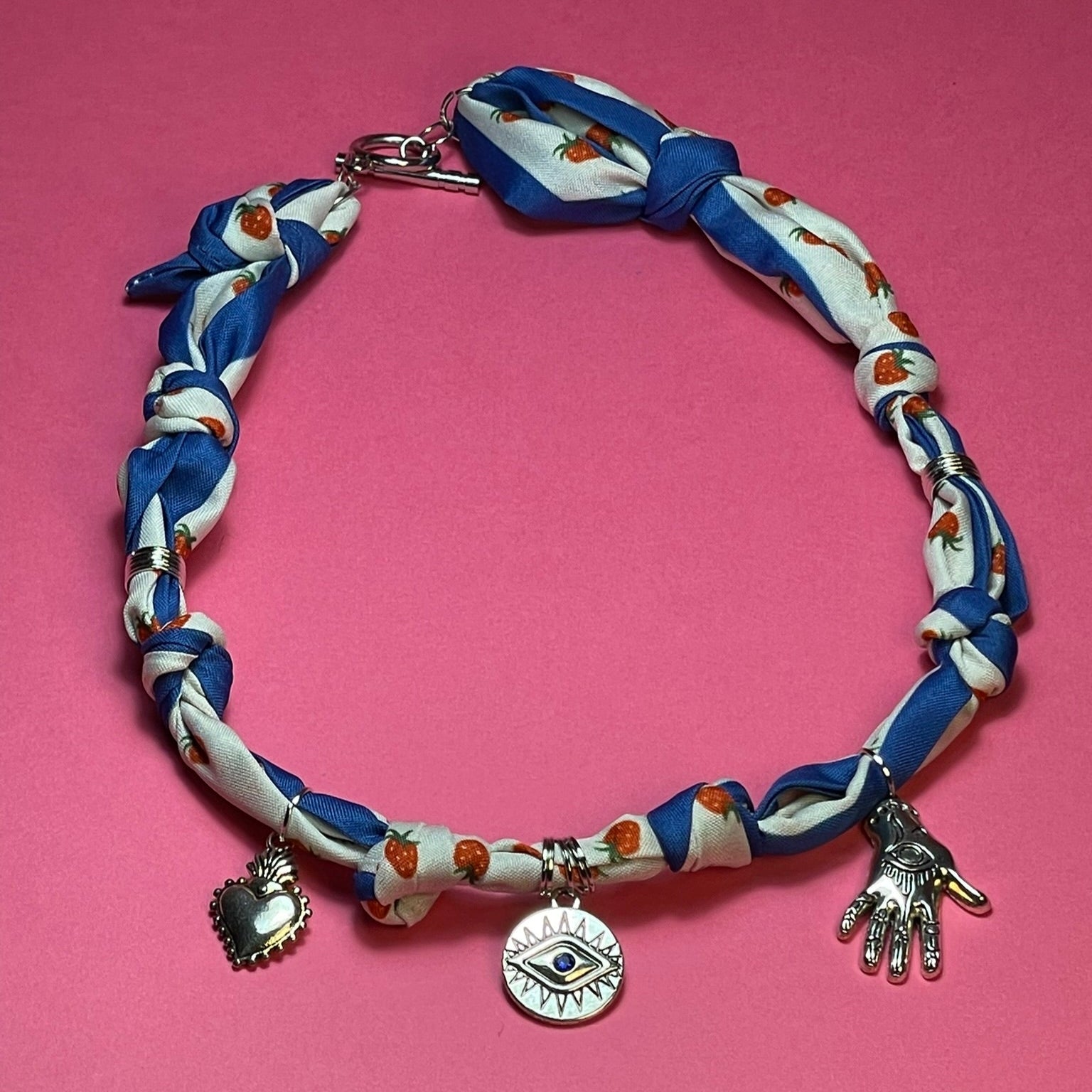 Collar artesanal con dije dorado y pañuelo trenzado, diseño bohemio hecho a mano por Hilma.