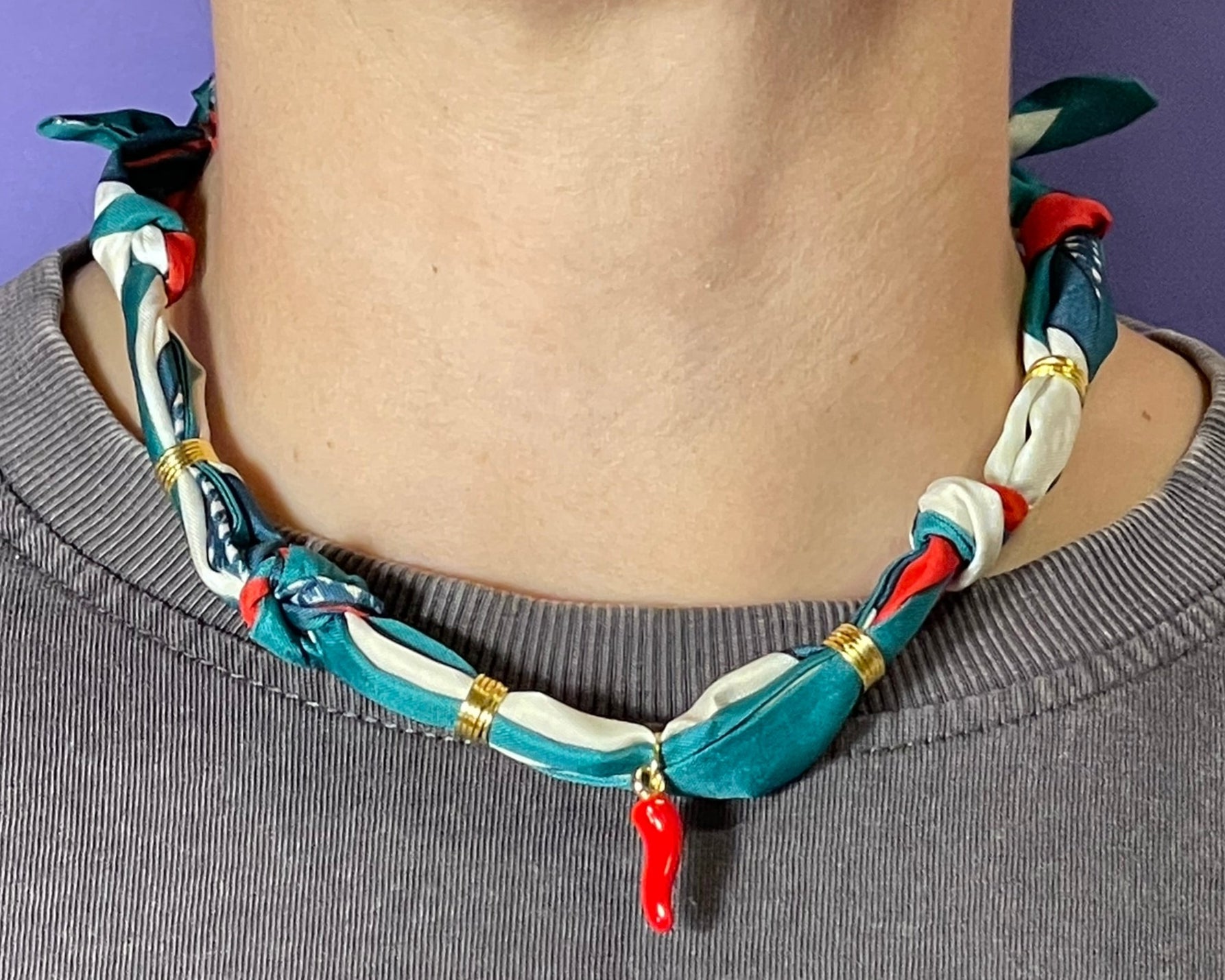 Collar artesanal con dije dorado y pañuelo trenzado, diseño bohemio hecho a mano por Hilma.