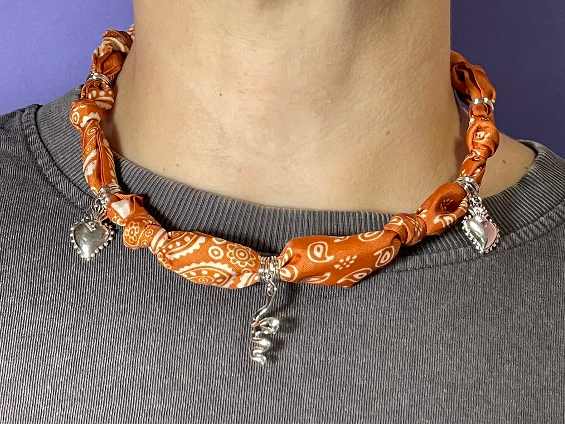 Collar artesanal con dije dorado y pañuelo trenzado, diseño bohemio hecho a mano por Hilma.