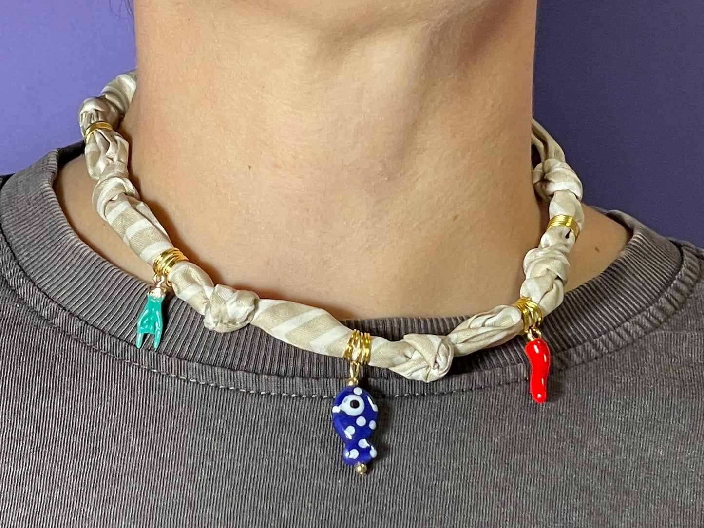 Collar artesanal con dije dorado y pañuelo trenzado, diseño bohemio hecho a mano por Hilma.