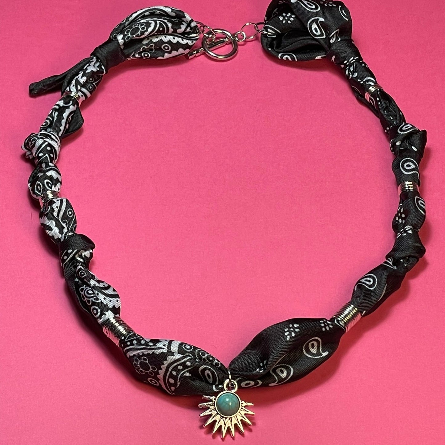 Collar artesanal con dije dorado y pañuelo trenzado, diseño bohemio hecho a mano por Hilma.