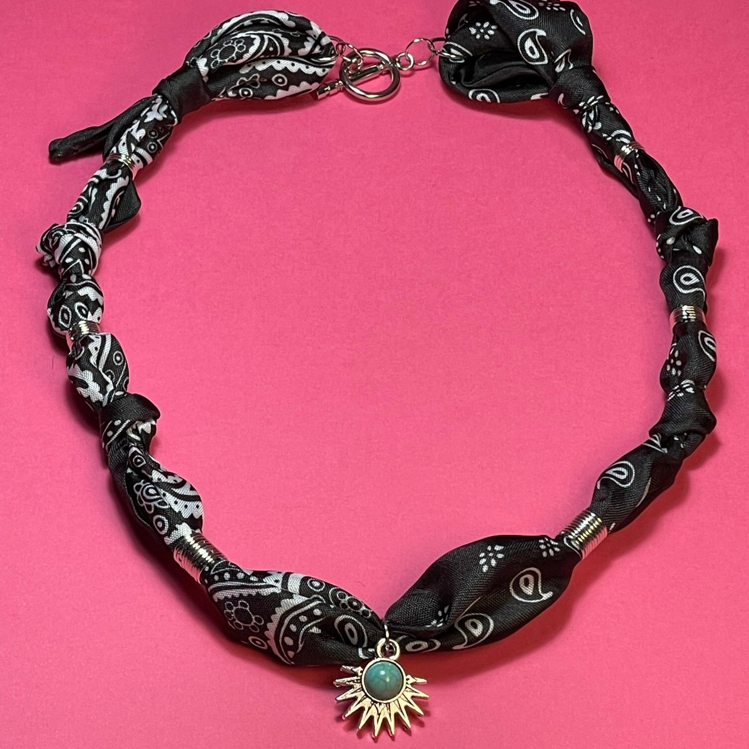 Collar artesanal con dije dorado y pañuelo trenzado, diseño bohemio hecho a mano por Hilma.