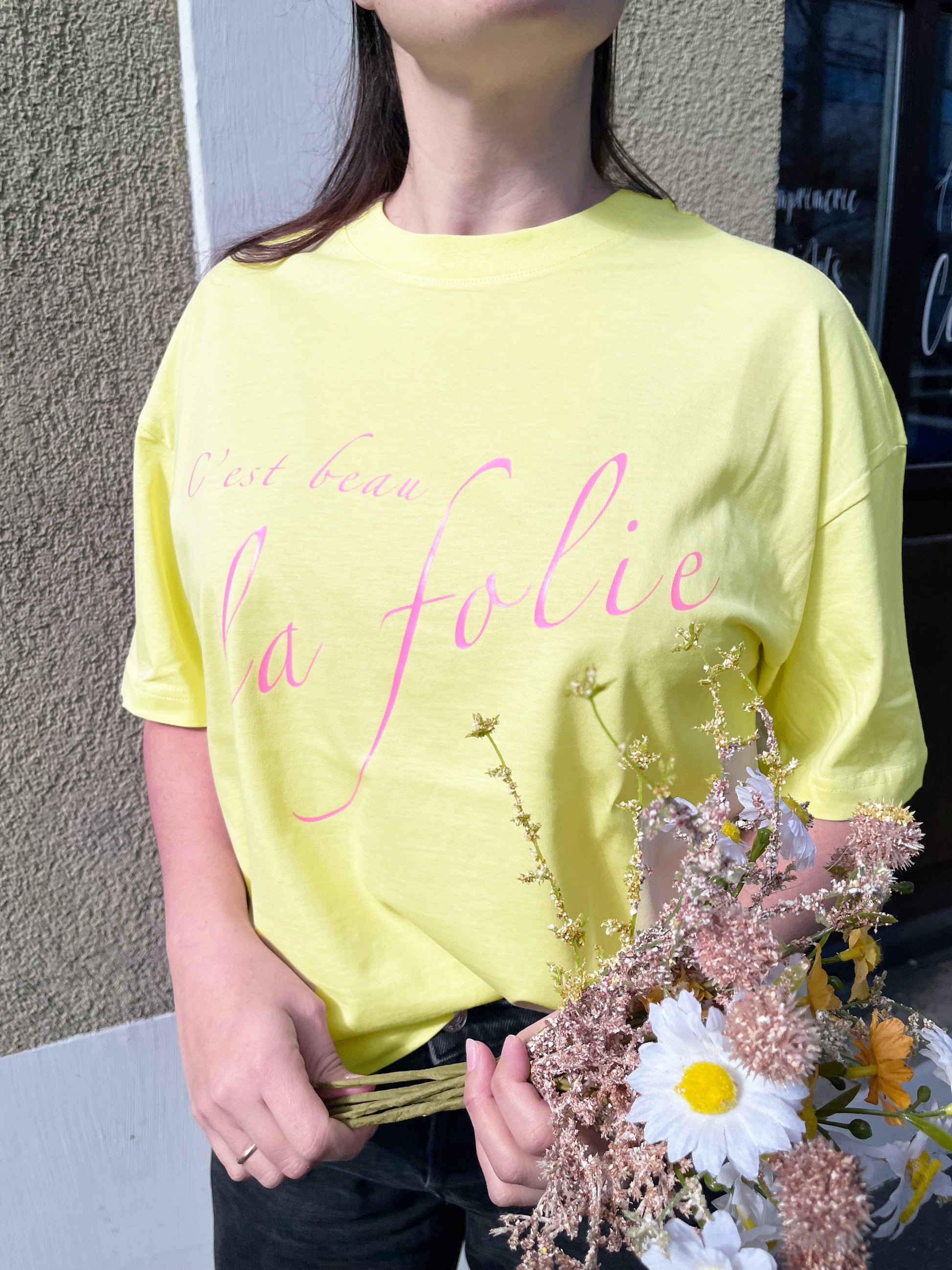 Camiseta boxy amarilla de algodón orgánico con mensaje C'est beau la folie en rosa Hilma Studio