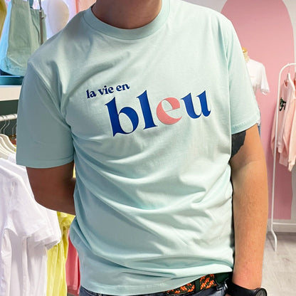 Camiseta unisex azul claro de algodón orgánico con mensaje La vie en bleu en azul y terciopelo rosa Hilma Studio