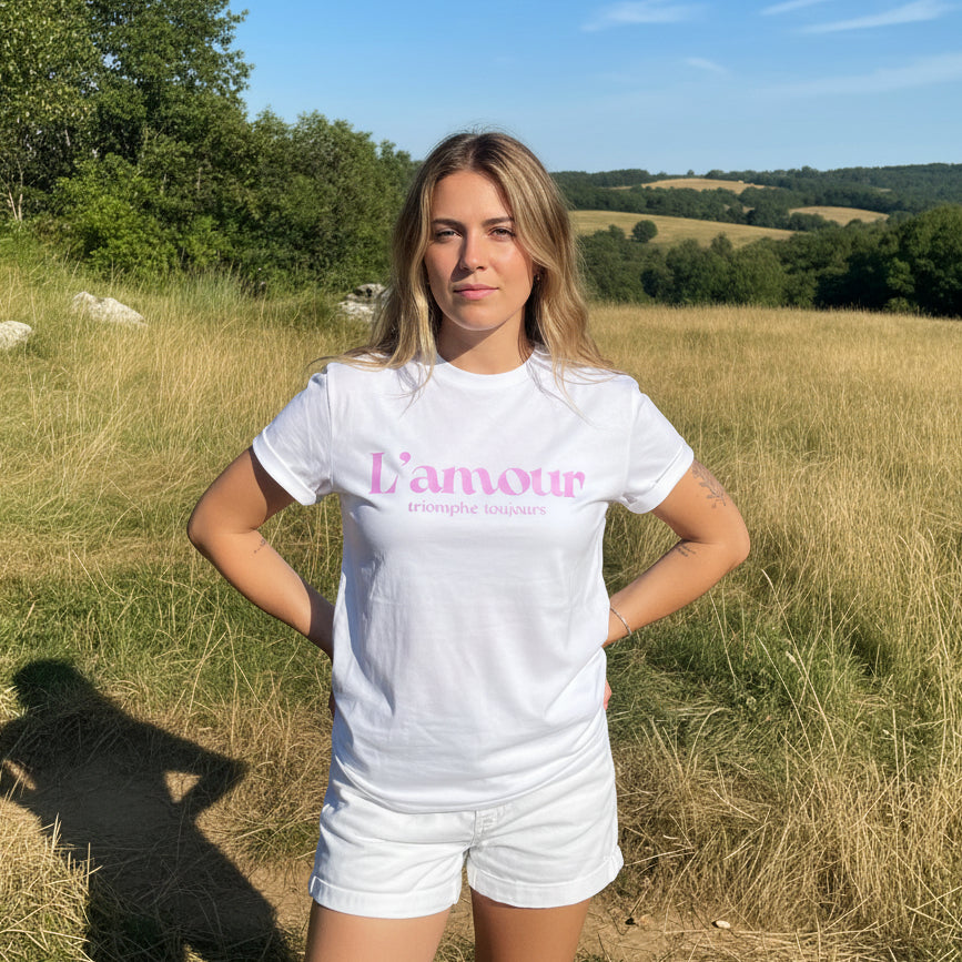 Camiseta unisex blanca de algodón orgánico con mensaje L'amour triomphe toujours en rosa metálico Hilma Studio