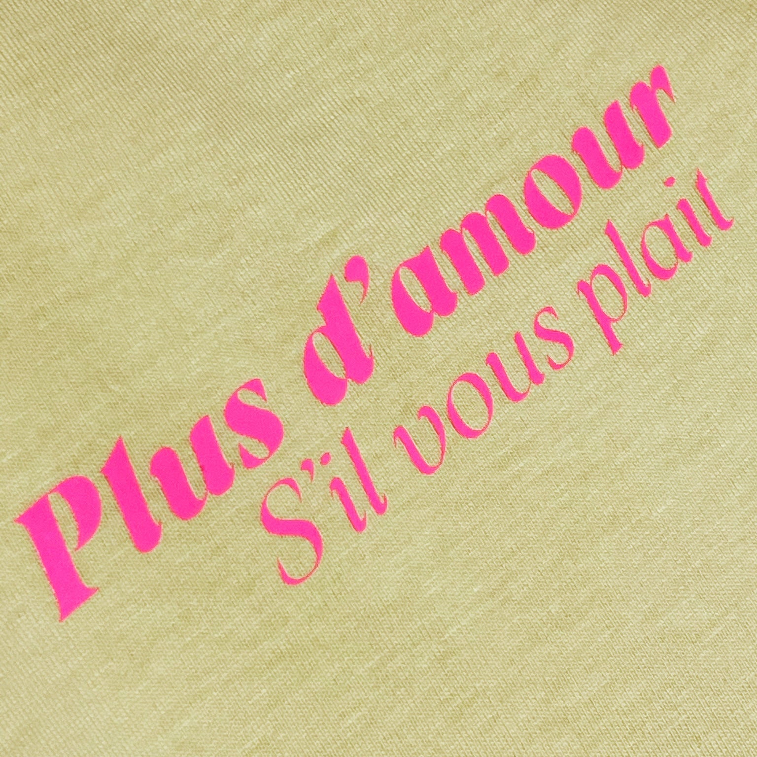 Detalle camiseta amarilla de algodón con mensaje Plus d'amour s'il vous plait en rosa flúor Hilma Studio