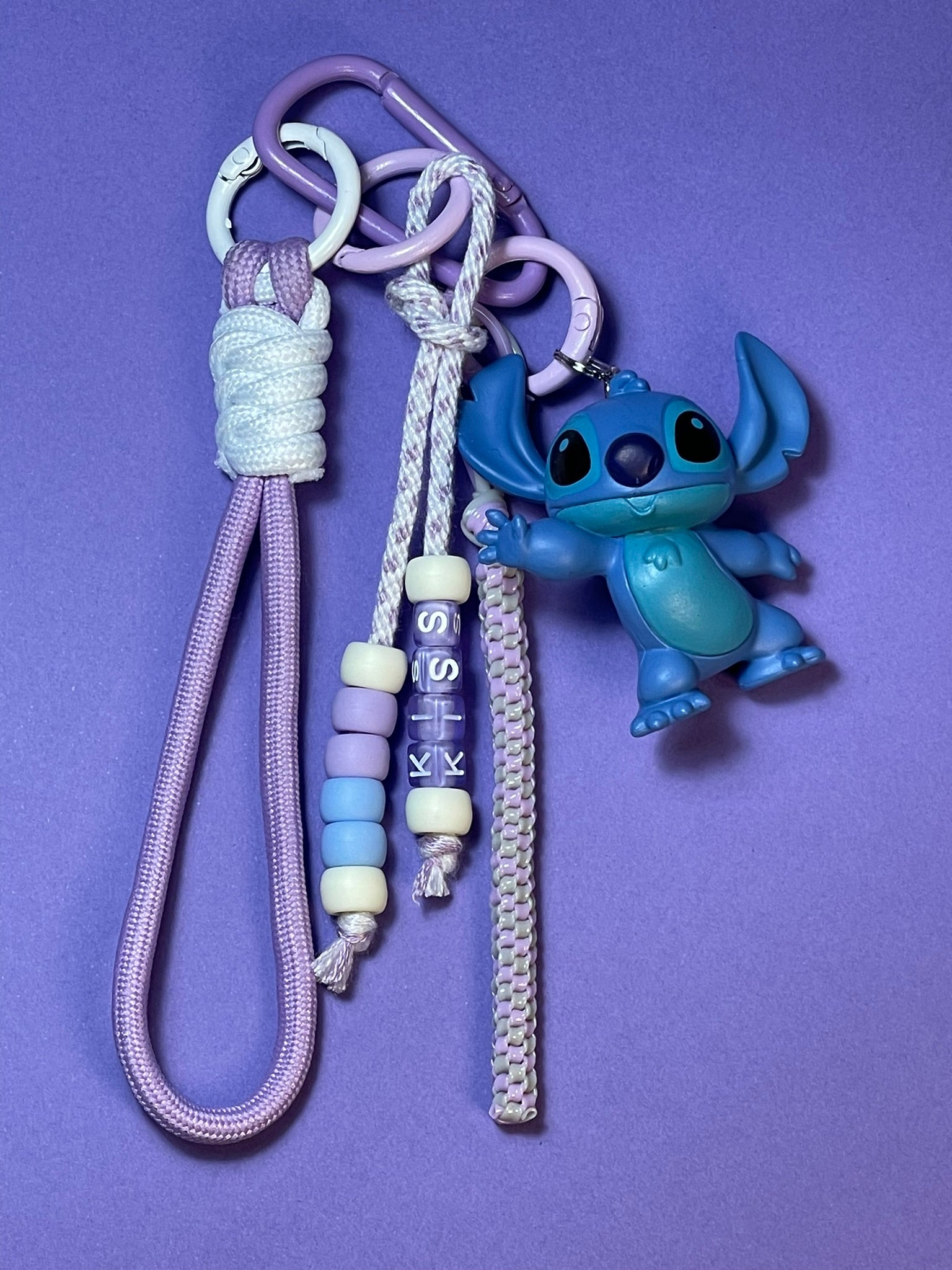 Llavero artesanal colorido con colgantes decorativos y cordones.