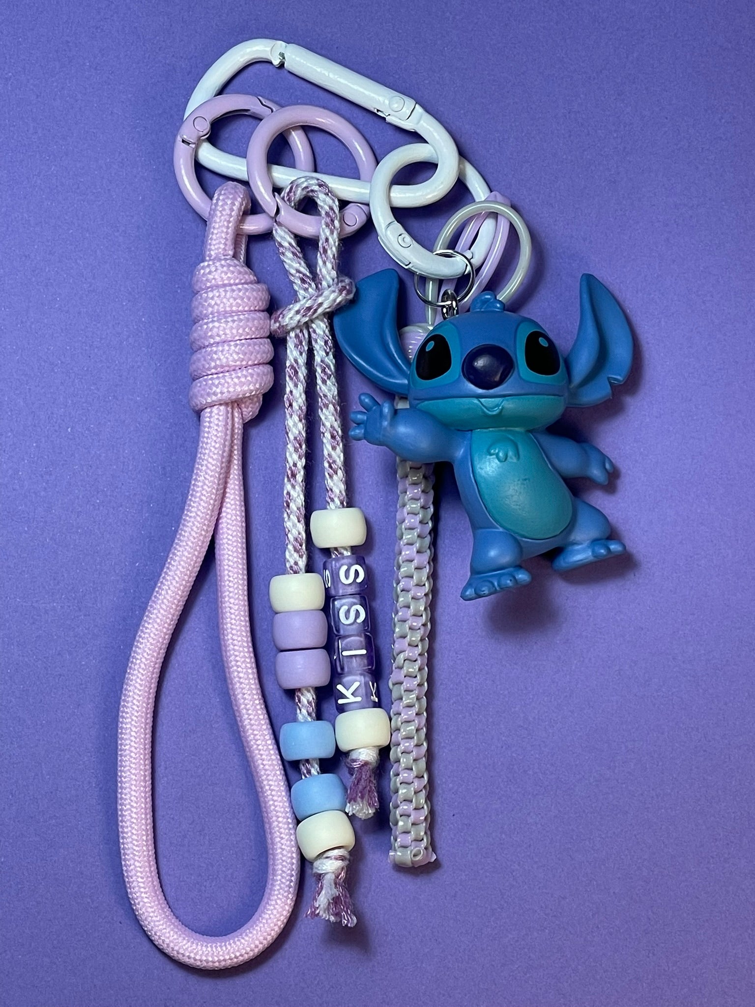 Llavero artesanal colorido con colgantes decorativos y cordones.