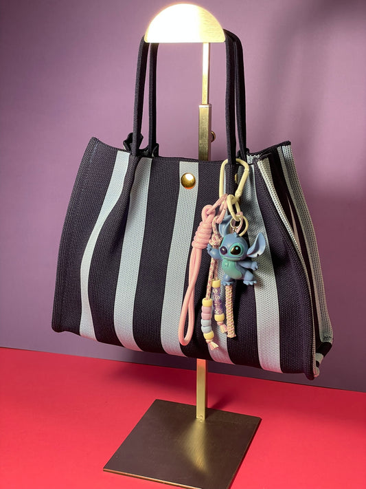 Llavero artesanal colorido con colgantes decorativos y cordones.