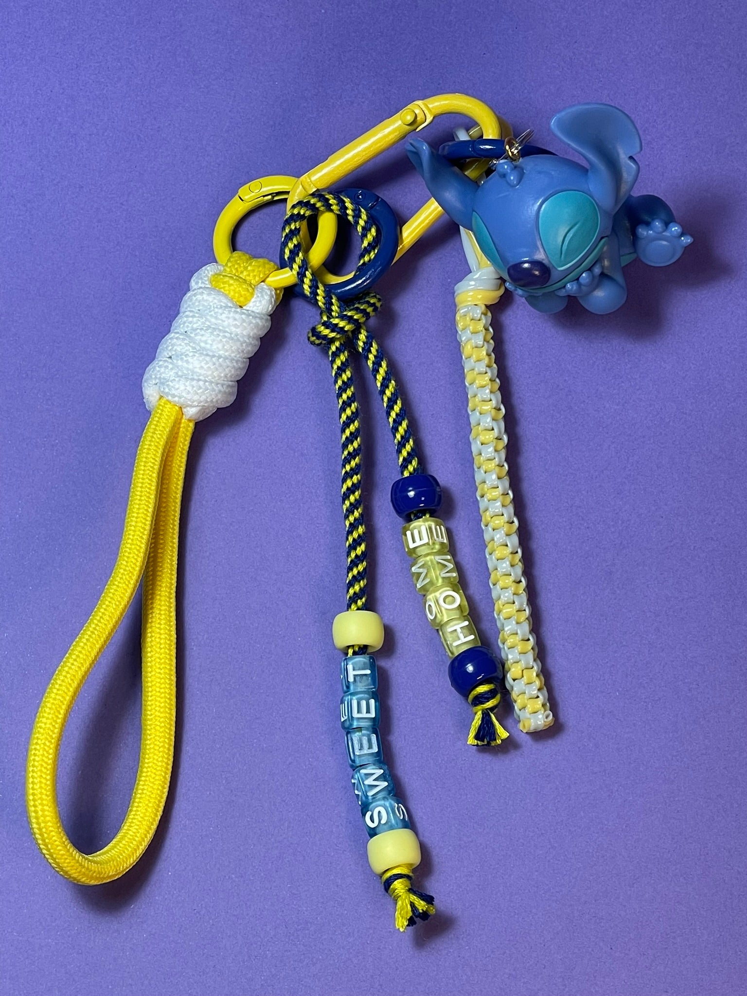 Llavero artesanal colorido con colgantes decorativos y cordones.