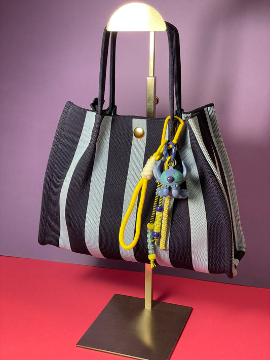 Llavero artesanal colorido con colgantes decorativos y cordones.