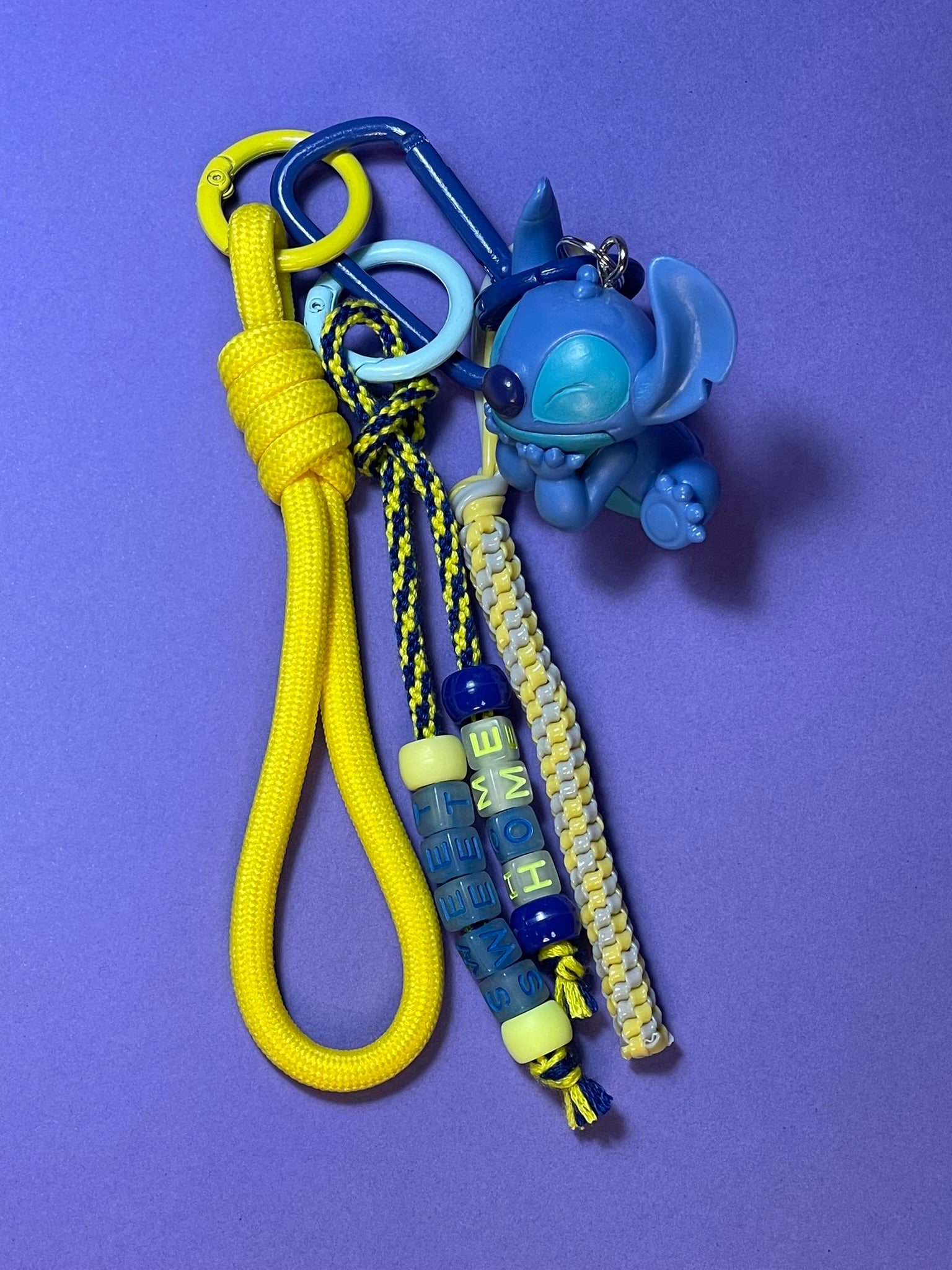 Llavero artesanal colorido con colgantes decorativos y cordones.