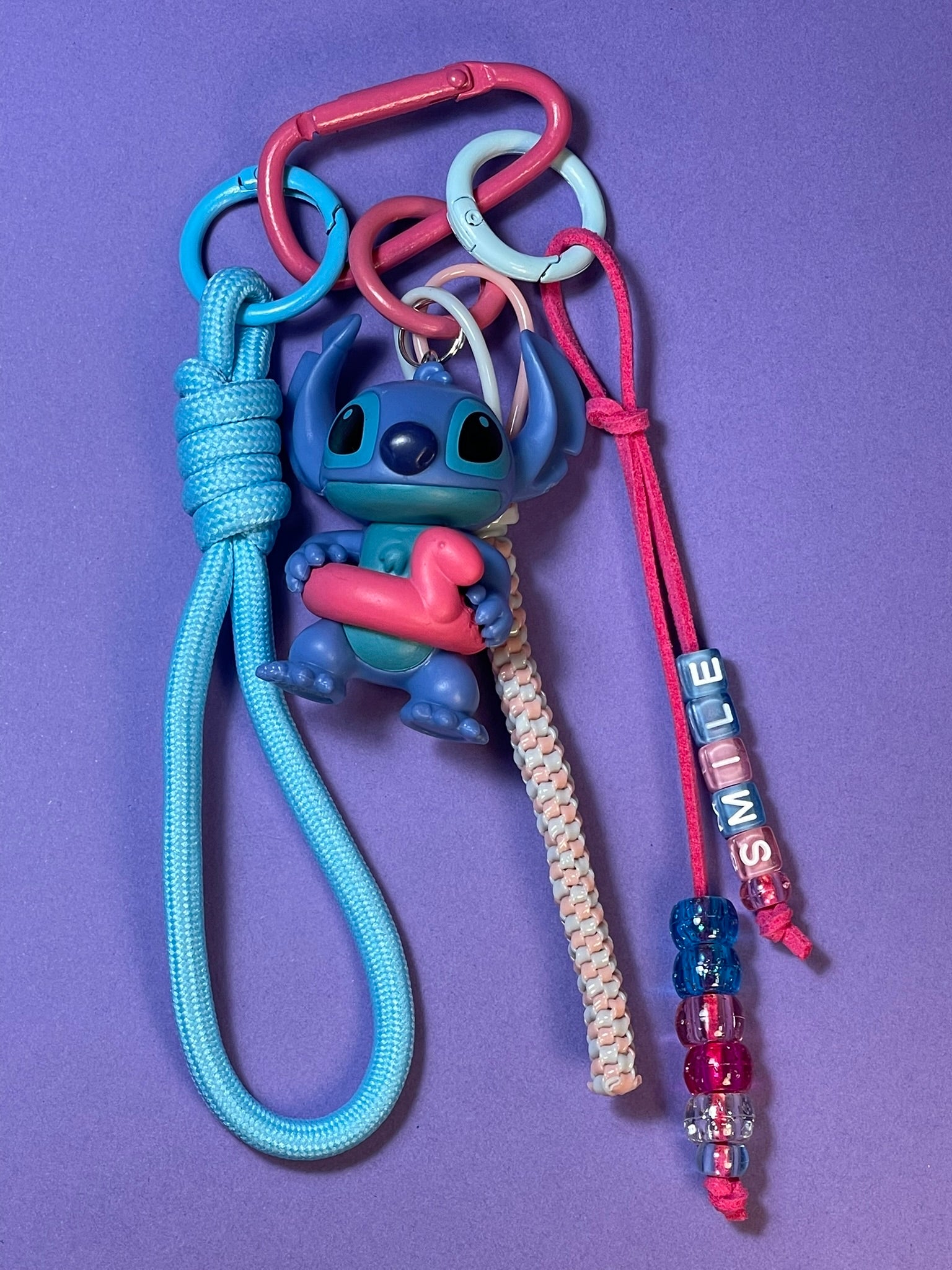 Llavero artesanal colorido con colgantes decorativos y cordones.