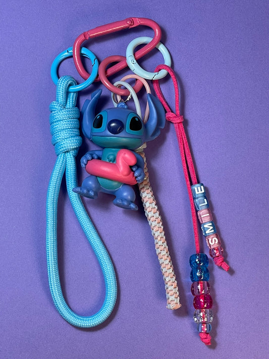 Llavero artesanal colorido con colgantes decorativos y cordones.