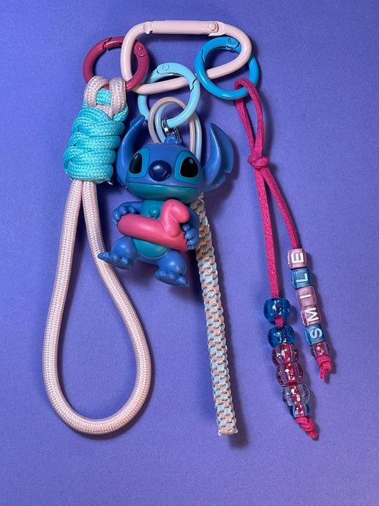 Llavero artesanal colorido con colgantes decorativos y cordones.