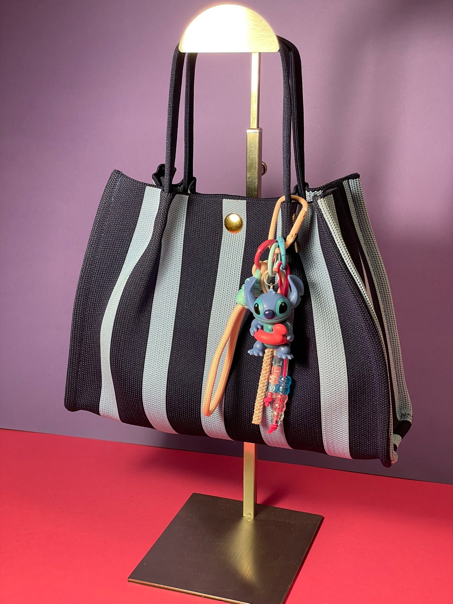 Llavero artesanal colorido con colgantes decorativos y cordones.