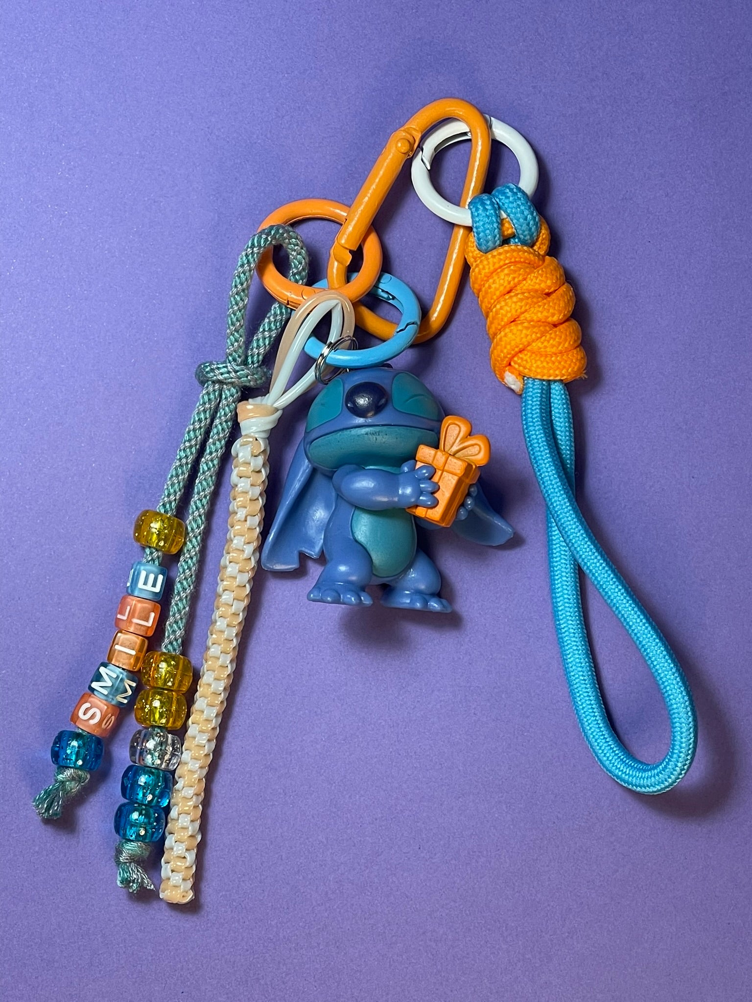 Llavero artesanal colorido con colgantes decorativos y cordones.