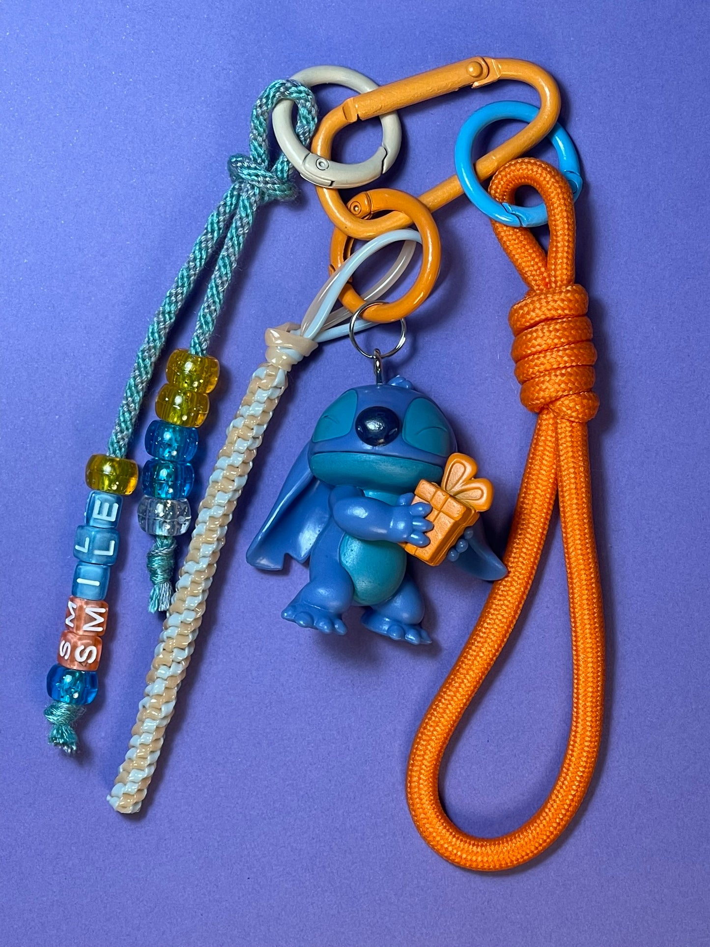 Llavero artesanal colorido con colgantes decorativos y cordones.