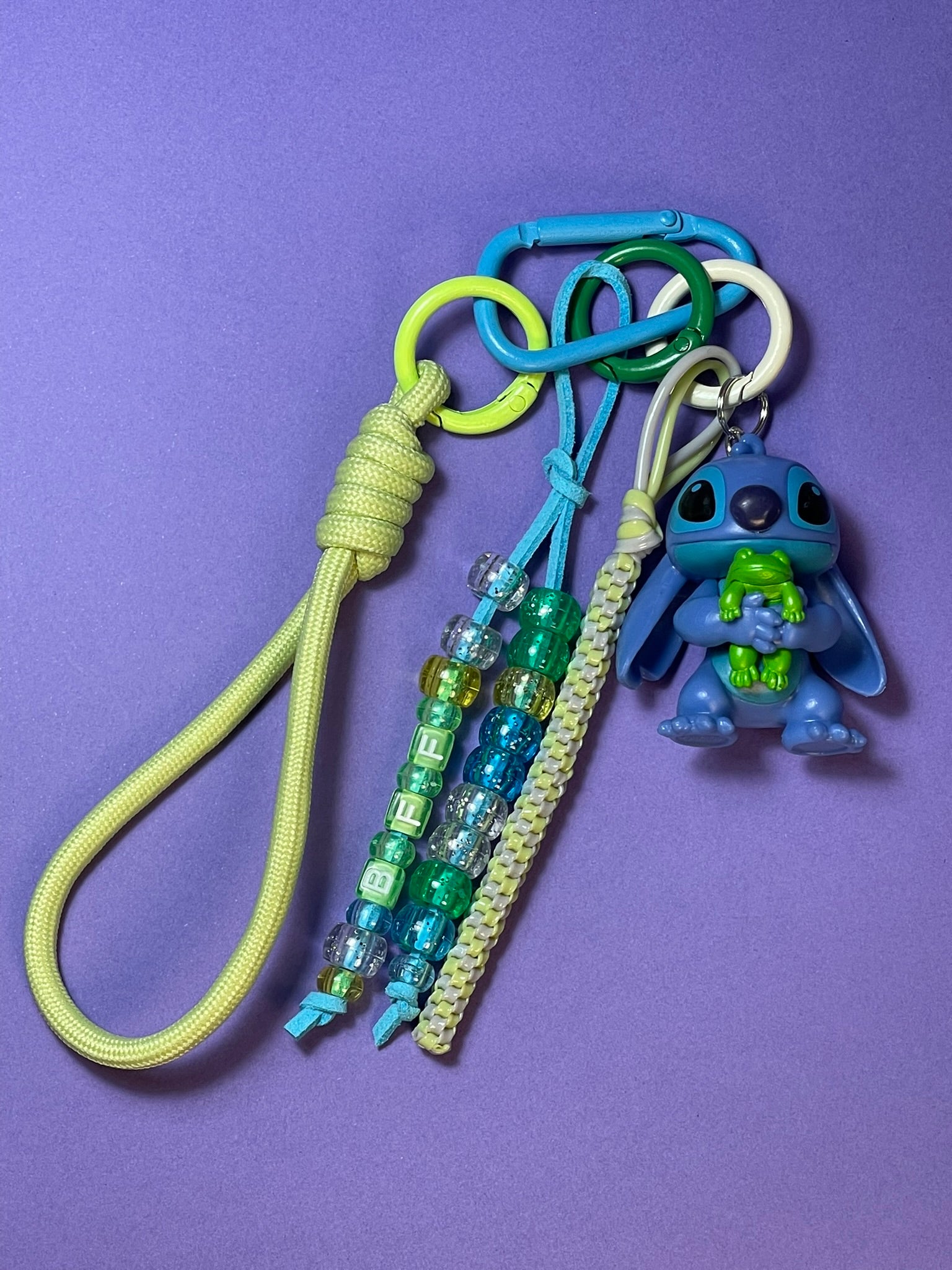 Llavero artesanal colorido con colgantes decorativos y cordones.