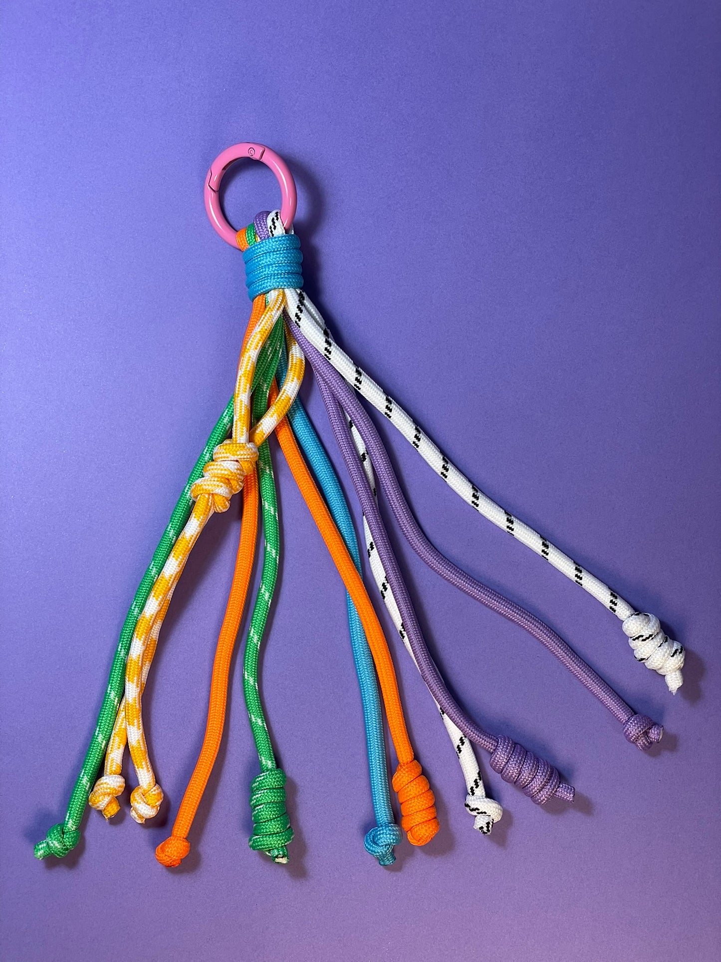 Llavero artesanal colorido con colgantes decorativos y cordones.