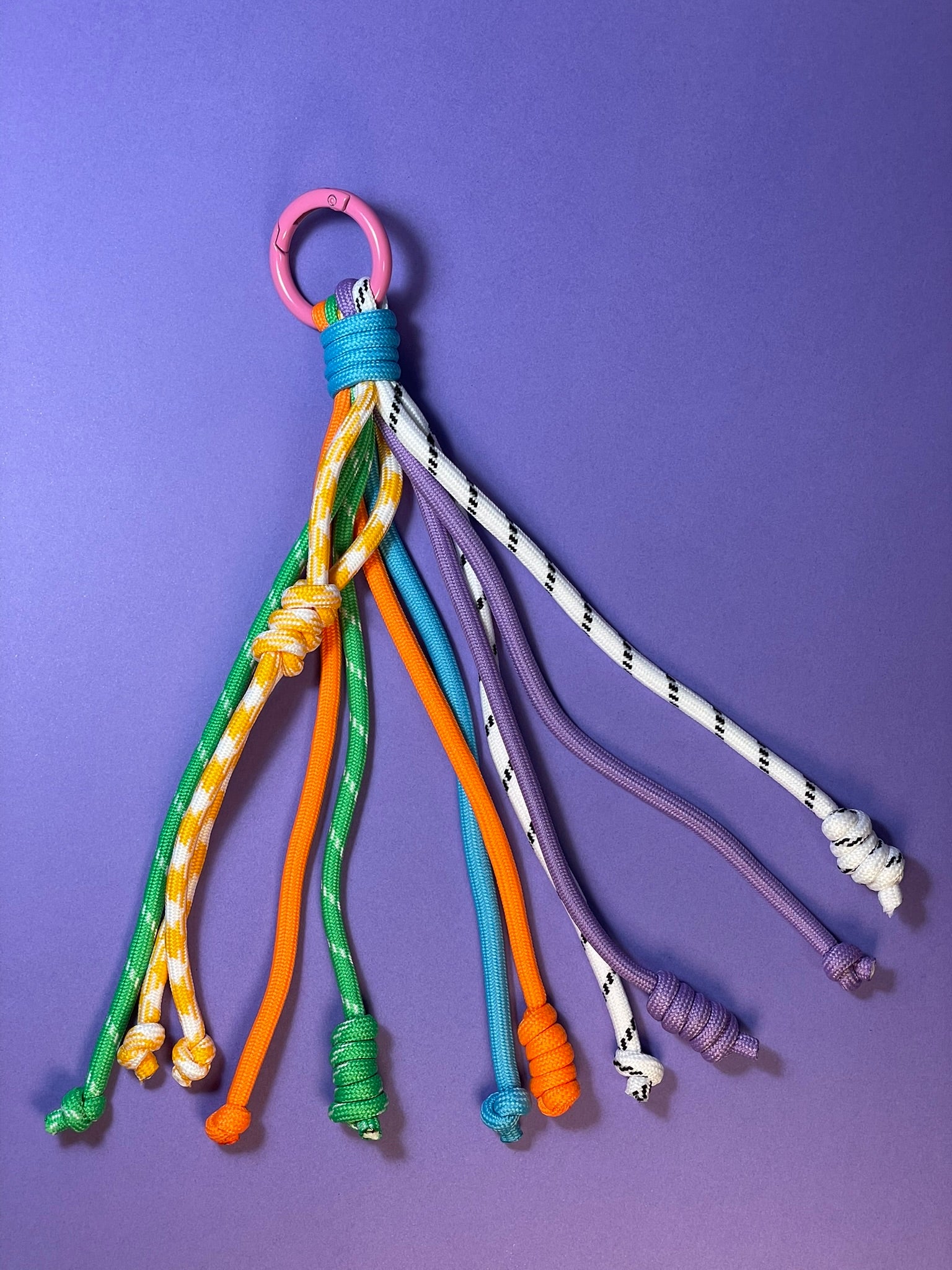 Llavero artesanal colorido con colgantes decorativos y cordones.