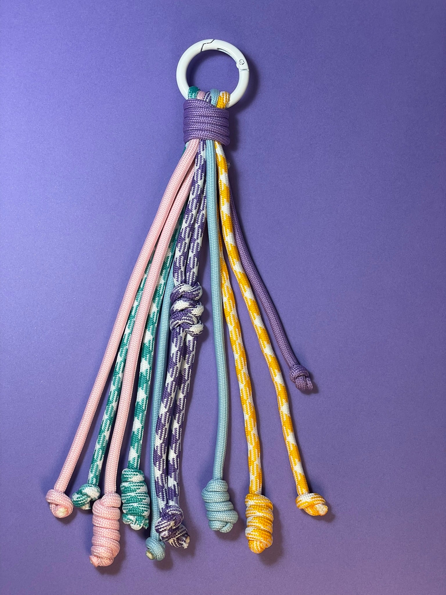 Llavero artesanal colorido con colgantes decorativos y cordones.