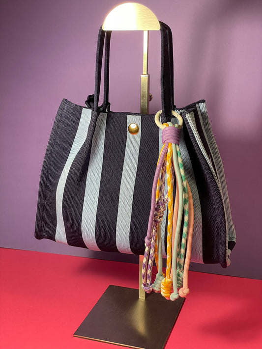 Llavero artesanal colorido con colgantes decorativos y cordones.