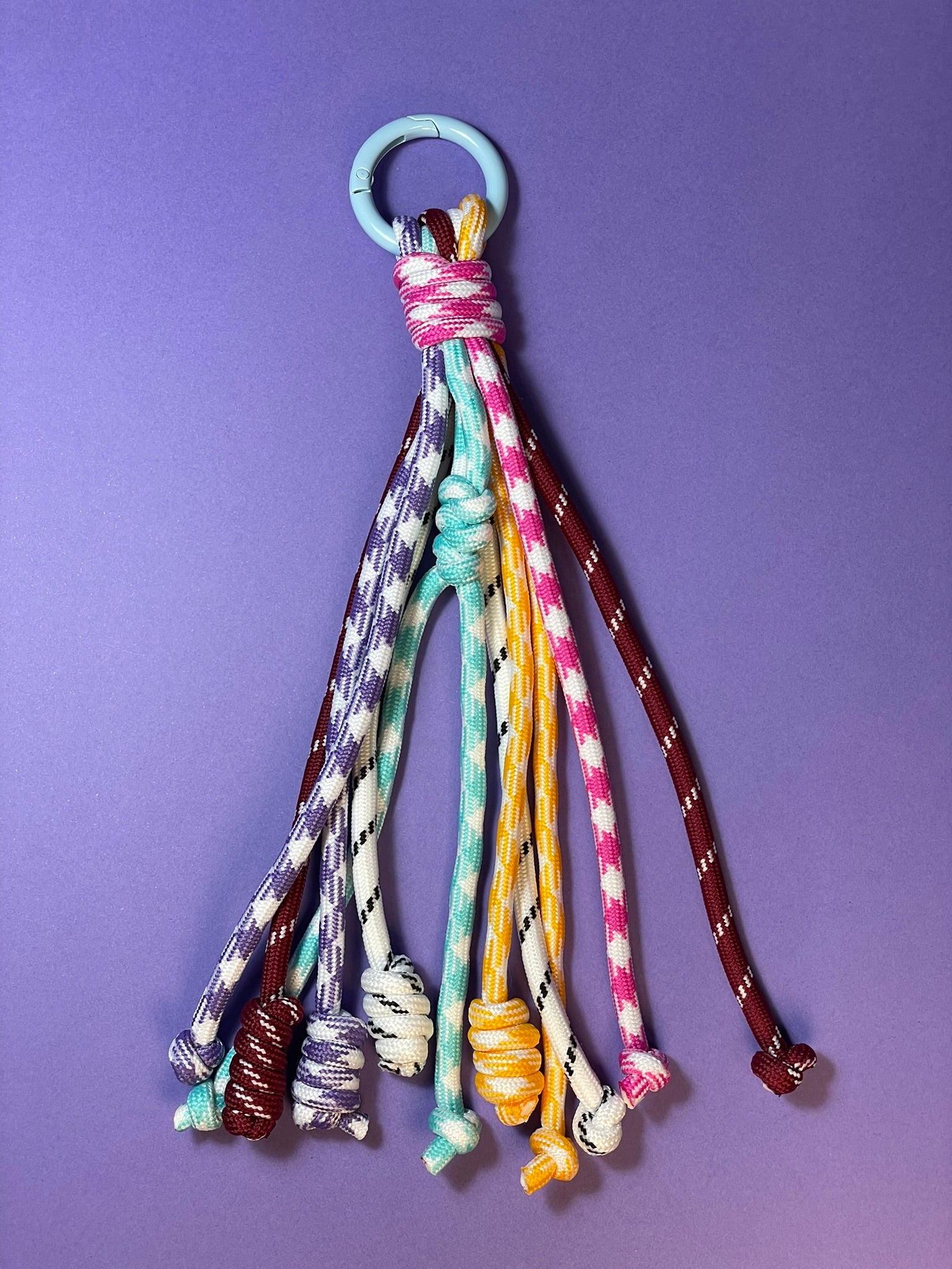 Llavero artesanal colorido con colgantes decorativos y cordones.