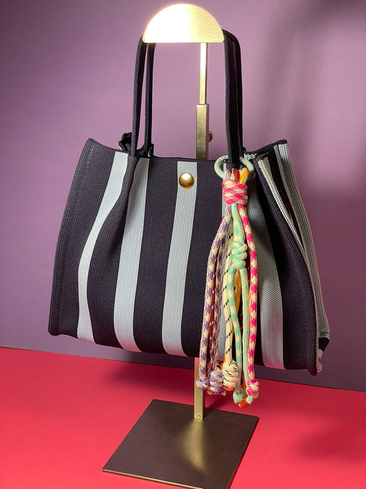 Llavero artesanal colorido con colgantes decorativos y cordones.