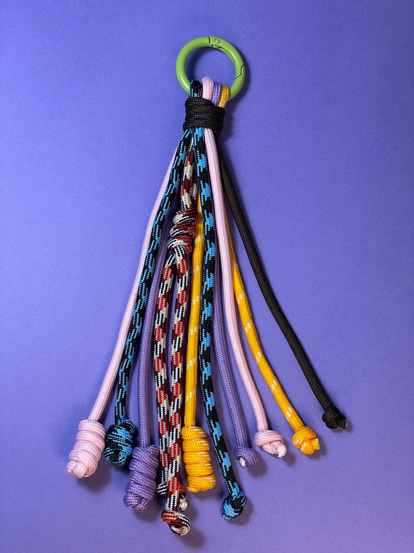 Llavero artesanal colorido con colgantes decorativos y cordones.