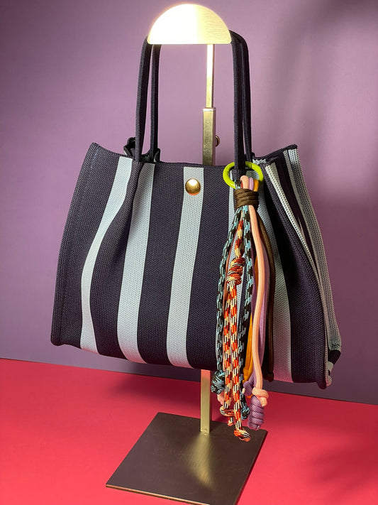 Llavero artesanal colorido con colgantes decorativos y cordones.