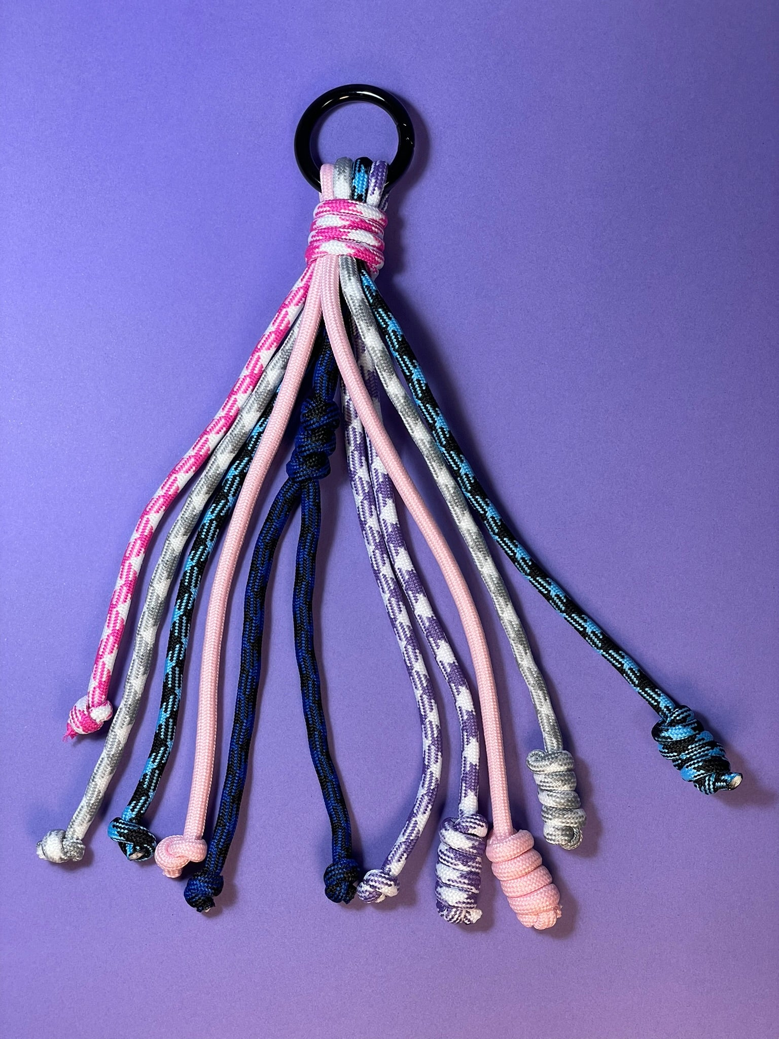 Llavero artesanal colorido con colgantes decorativos y cordones.