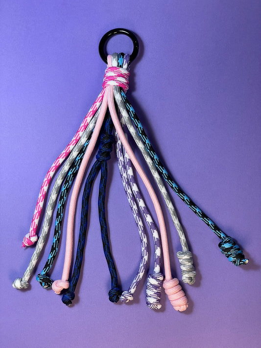 Llavero artesanal colorido con colgantes decorativos y cordones.