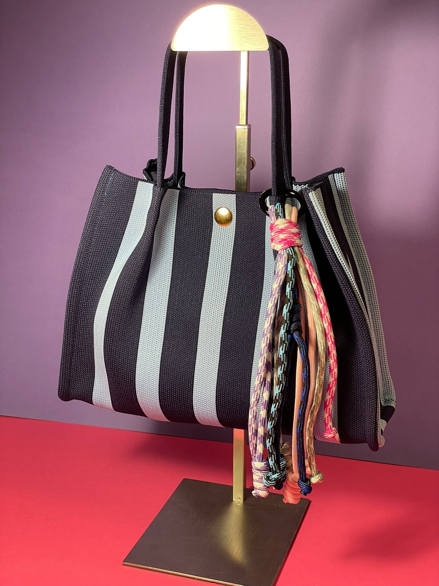 Llavero artesanal colorido con colgantes decorativos y cordones.