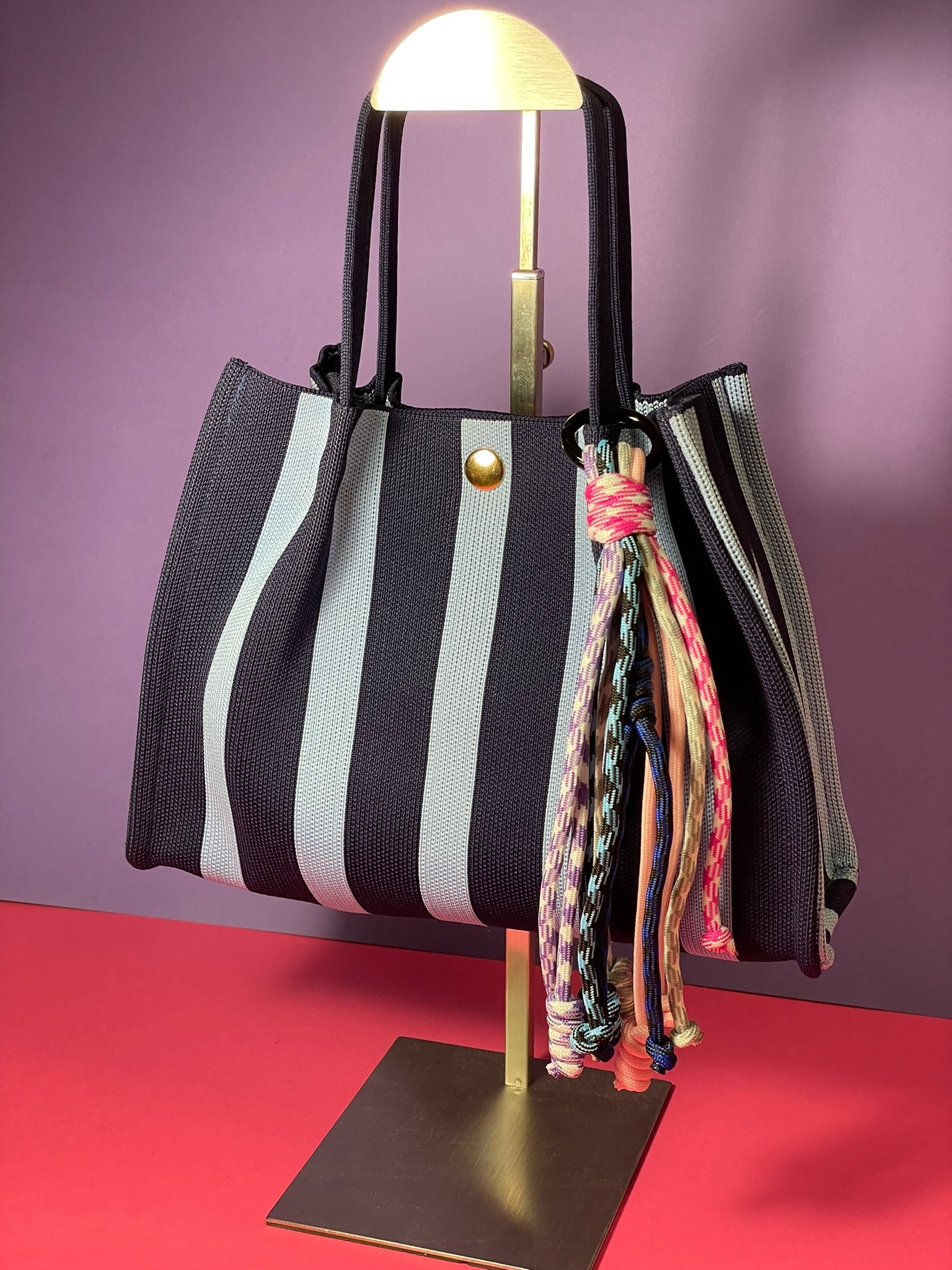 Llavero artesanal colorido con colgantes decorativos y cordones.