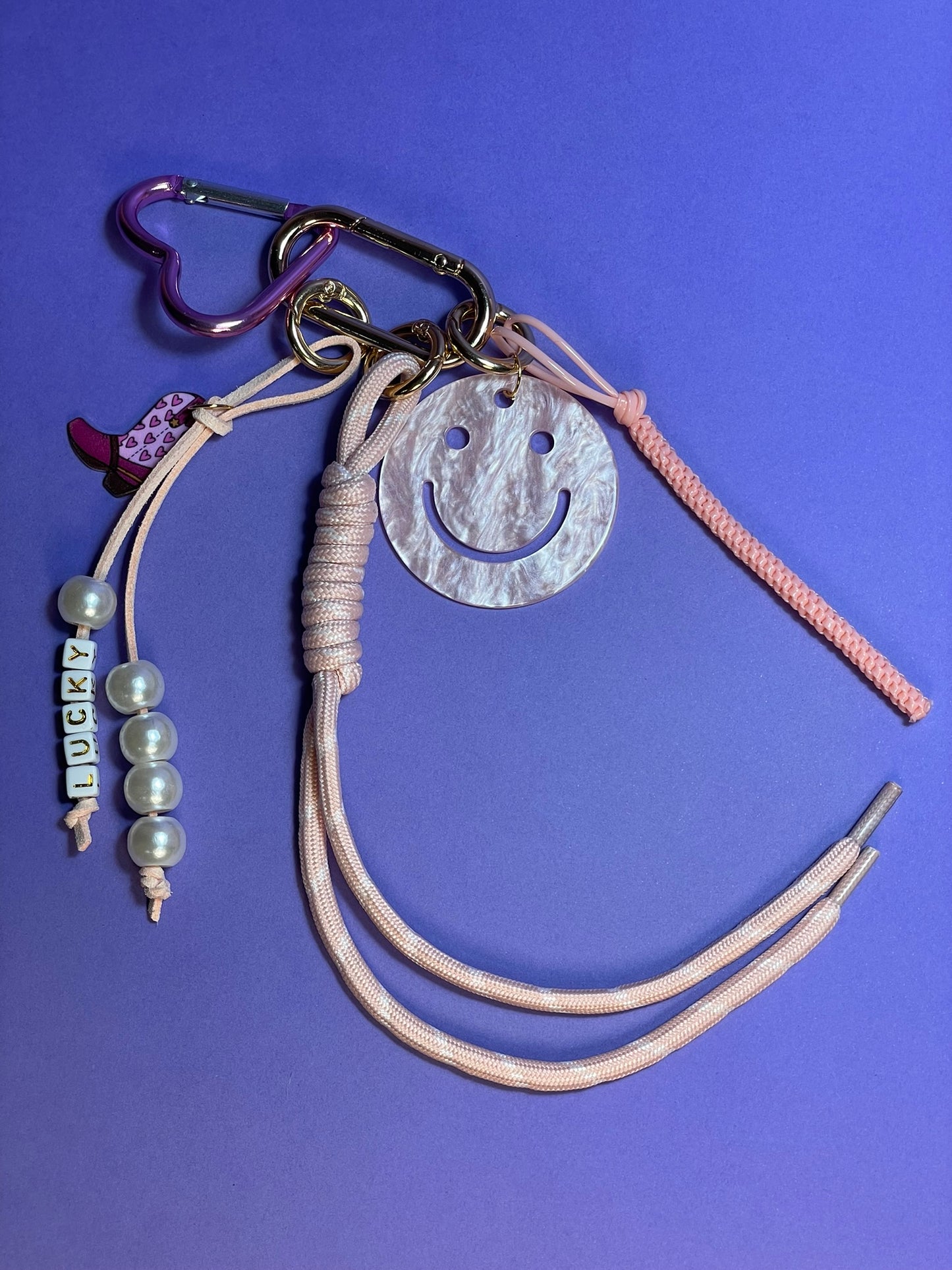 Llavero artesanal colorido con colgantes decorativos y cordones.