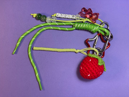 Llavero artesanal colorido con colgantes decorativos y cordones.