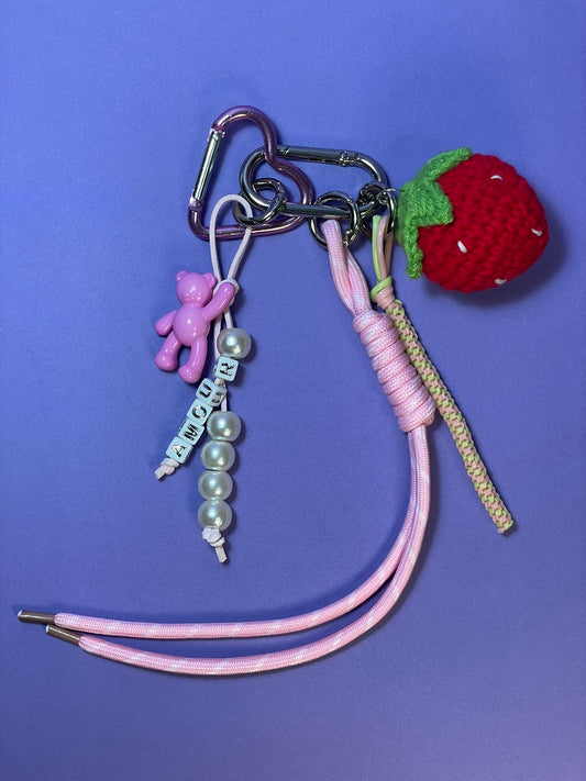 Llavero artesanal colorido con colgantes decorativos y cordones.