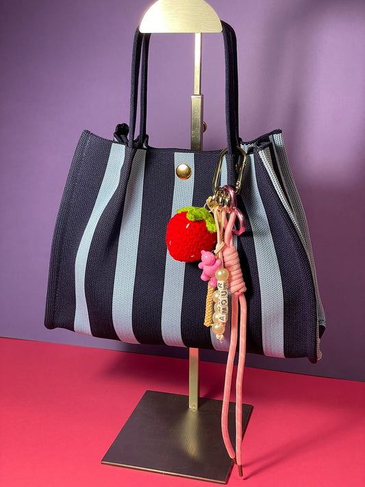 Llavero artesanal colorido con colgantes decorativos y cordones.