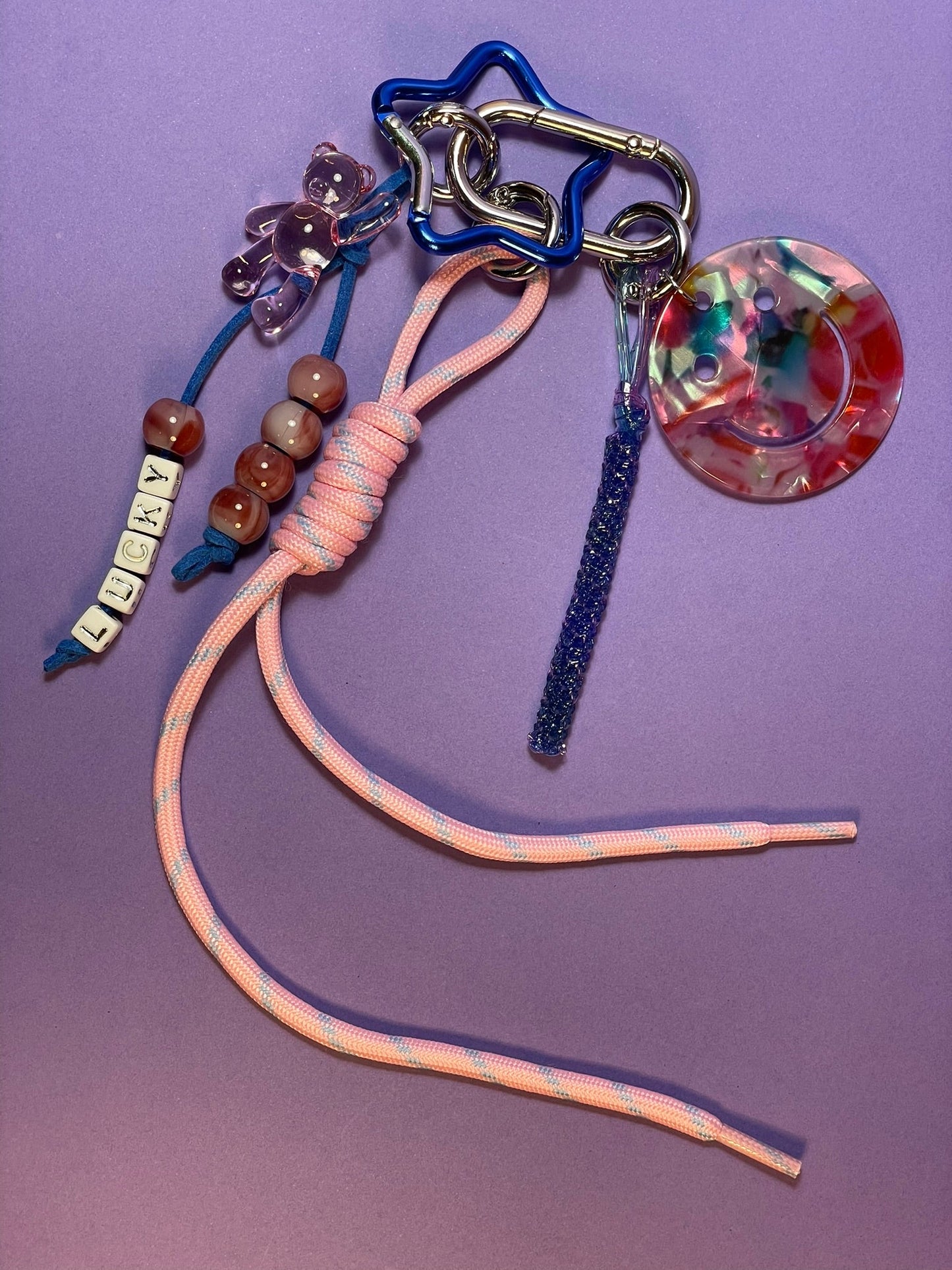 Llavero artesanal colorido con colgantes decorativos y cordones.