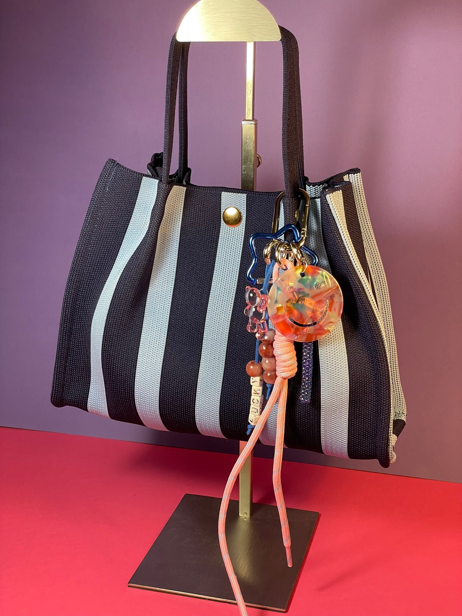 Llavero artesanal colorido con colgantes decorativos y cordones.