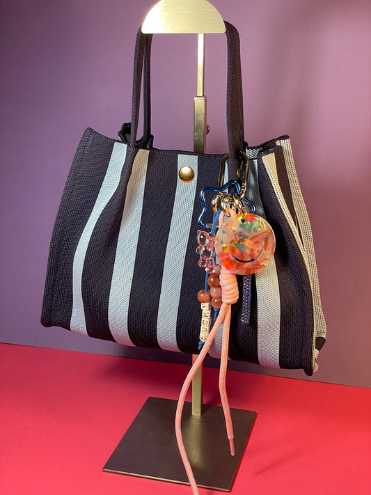 Llavero artesanal colorido con colgantes decorativos y cordones.