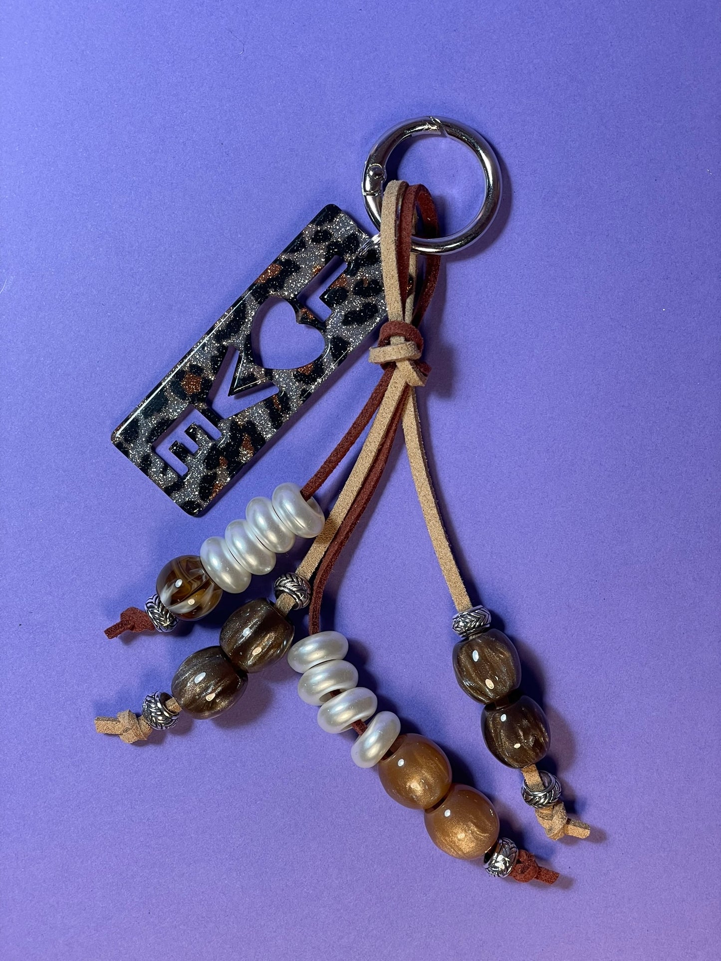 Llavero artesanal colorido con colgantes decorativos y cordones.