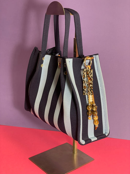 Llavero artesanal colorido con colgantes decorativos y cordones.