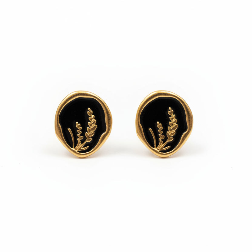 Pendientes dorados de acero inoxidable en forma circular negra con dibujo Hilma Studio
